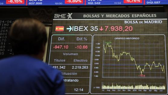 Una mujer observa en las pantallas el desplome del Ibex este viernes por el Brexit