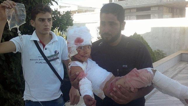 Una niña herida es sacada del hospital por dos parientes cerca de Homs, en julio de 2012