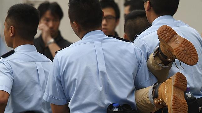 Agentes de la Policía trasladan a un detenido durante las multitudinarias protestas en Hong Kong