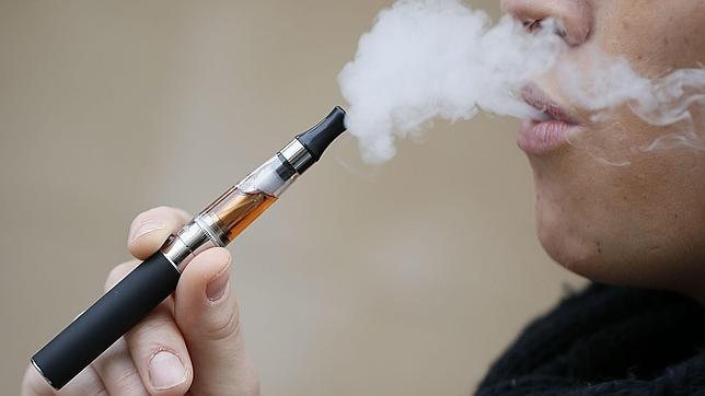 Una joven fuma un modelo de cigarrilo electrónico