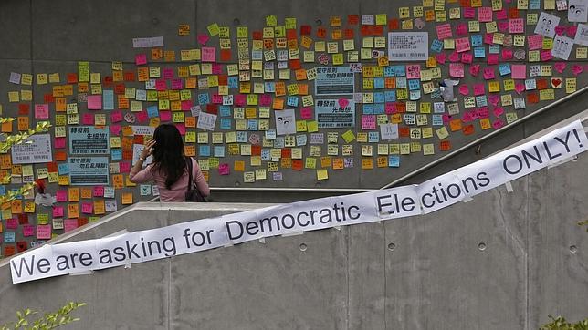 Una mujer mira los carteles prodemocracia en Hong Kong