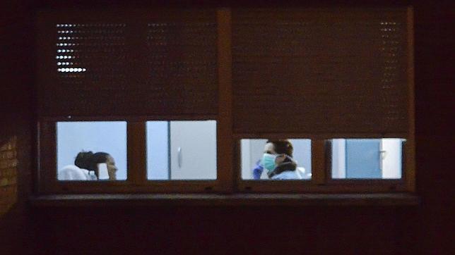 Ün miembro de la plantilla sanitaria del hospital Carlos III de Madrid atiende a una de las personas aisladas para ser controladas por posible caso de alarma