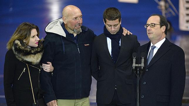 Serge Lazarevic (c) junto a sus hijos y el presidente francés a su llegada a París