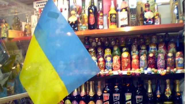 La bandera de Ucrania sobre un fondo formado de muñecas rusas, en una tienda de comida de Europa del este.