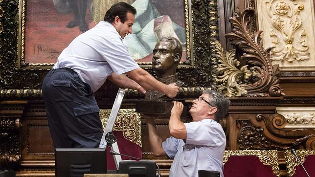 Los operarios municipales retiran el busto del Rey Juan Carlos I en el salón de Plenos del Ayuntamiento de Barcelona