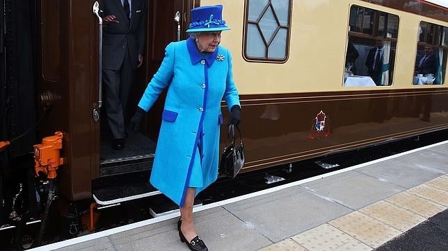 Isabel II con todas las prendas de esta temporada: atuendo monocolor, bolso de mano de los años 50, tacón grueso, guantes y broche