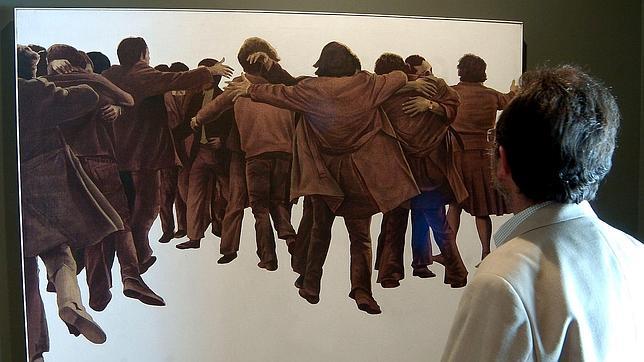Un hombre admira «El abrazo», de Juan Genovés