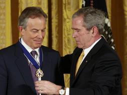 Momento en el que George W. Bush impone la condecoración al ex primer ministro británico Tony Blair durante la ceremonia que se ha celebrado en la Casa Blanca. /Reuters