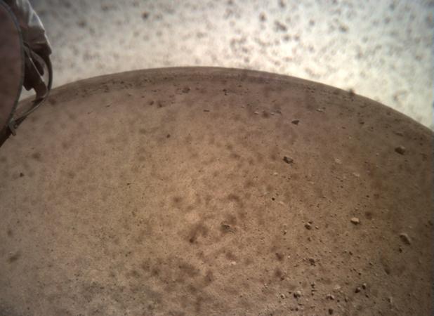 La nave espacial InSight abrió la tapa de la lente de su Cámara de Contexto de Instrumentos (ICC) el 30 de noviembre y capturó esta vista de Marte. Ubicada debajo de la cubierta del módulo de aterrizaje, la ICC tiene una vista de ojo de pez, creando un horizonte curvo.