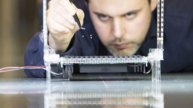 El investigador Asier Marzon observa las partículas levitando, comprobando la fuerza de las trampas acústicas