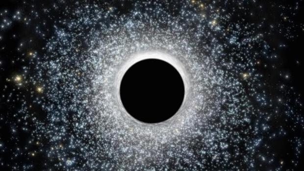 En la ilustración, un agujero negro de masa intermedia rodeado de estrellas. Los astrónomos los buscan en nuestra galaxia