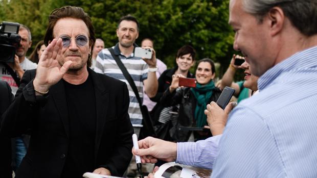 Bono, líder de U2, atiende a sus fans poco después de reunirse con la canciller alemana Angela Merkel en Berlín