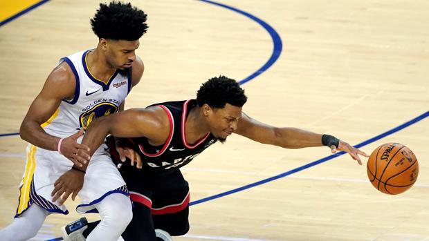El jugador de los Toronto Raptors, Kyle Lowry (d), va por un balón suelto contra el jugador de Golden State Warriors, Quinn Cook (i)