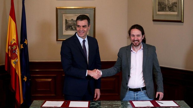 El presidente de Gobierno en funciones, Pedro Sánchez, al firmar un acuerdo de Ejecutivo en coalición con el líder de Unidas Podemos, Pablo Iglesias