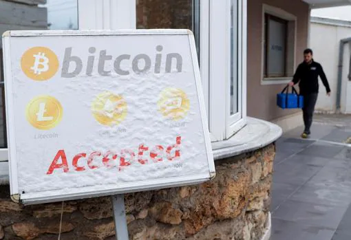 A bitcoin sign posted on the door of a cryptocurrency exchange office in Pristina, Serbia
