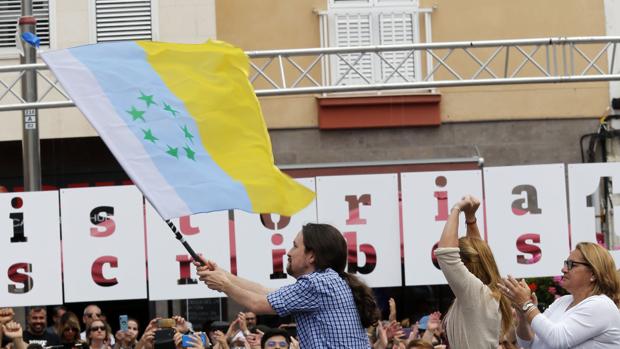 Pablo Iglesias con la bandera canaria de las siete estrellas verdes