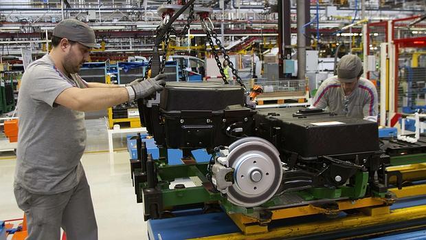 Dos operarios del centro vigués colocan las baterías de una Berlingo