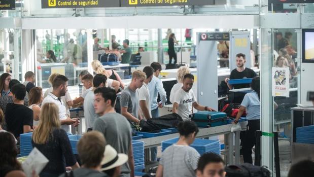 Viajeros, pasando los controles de seguridad tras hacer largas colas en El Prat