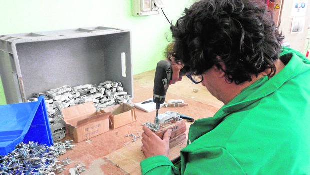 Un hombre trabaja en un taller de piezas de un Centro especial catalán