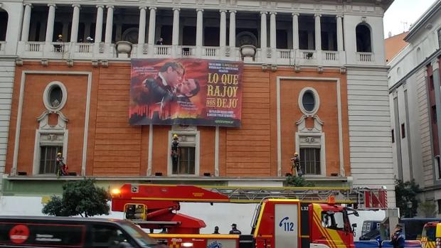Los bomberos intervienen para retirar la pancarta, desplegada esta misma mañana