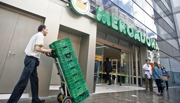 Imagen de un empleado de Mercadona frente a un supermercado de Mercadona en el centro de Valencia