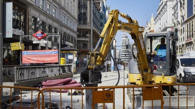 Una excavadora interviene en el pavimento de la Gran Vía a la altura de la calle de Montera