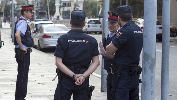 Agentes de la Policía hablan con efectivos de los Mossos en Barcelona