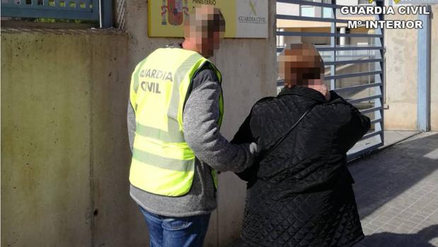 Uno de los detenidos custodiado por la Guardia Civil