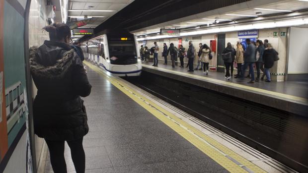 Viajeros esperan la llegada del Metro en una estación madrileña