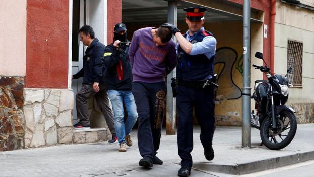 Los Mossos conducen al detenido tras el registro de su vivienda en Cornellá