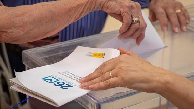 Una ciudadana deposita su voto en la urna este mediodía