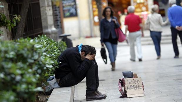 Un mendigo pide limosna en las calles de Valencia