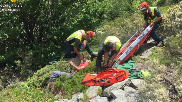 Tres agentes atienden al senderista en el lugar donde lo encontraron