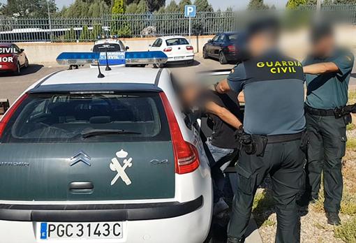 Uno de los detenidos es introducido en un vehículo de la Guardia Civil