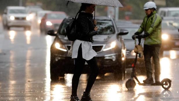 Transeúntes se desplazan bajo la lluvia este lunes en un municipio alicantino