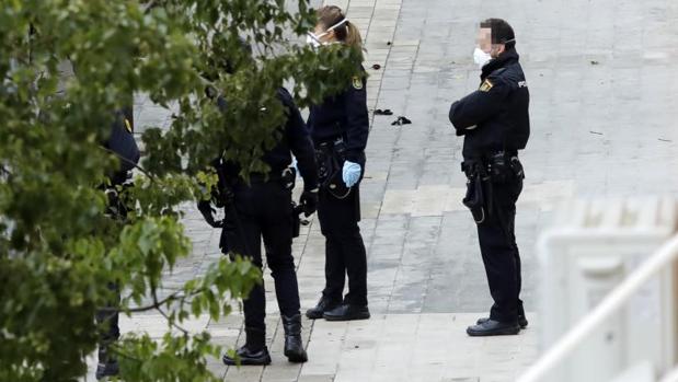 Varios policias patrullando protegidos con mascarilla por una calle de Alicante