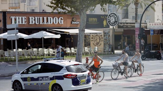 Imagen de una patrulla de la Policía Local de Benidorm junto a tres turistas sin mascarilla