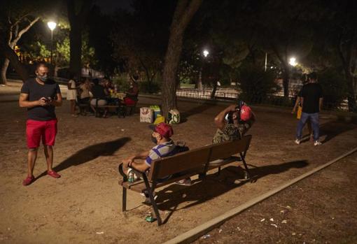 Varios grupos de personas consumen cervezas en un parque de Villaverde