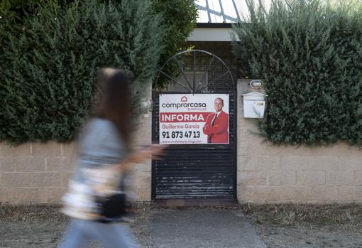 Cartel de una inmobiliaria en la puerta de una vivienda vacía