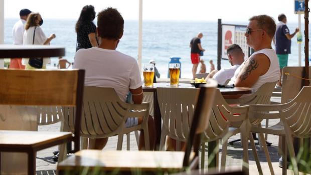 Turistas en una terraza junto a la playa en Benidorm