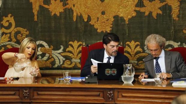 El secretario del Ayuntamiento de Alicante, consultanndo documentos en un Pleno junto al alcalde y la vicealcaldesa