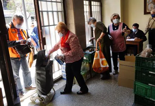 Varias mujeres mayores recogen productos básicos en el convento de capuchinos