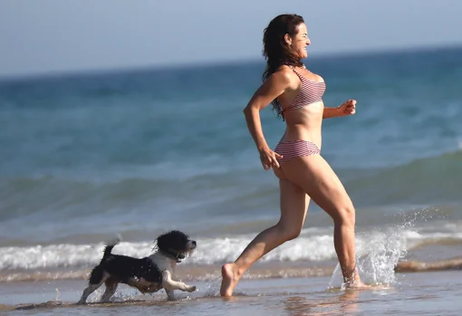 Belén López with her dog on the beach is the spitting image of happiness