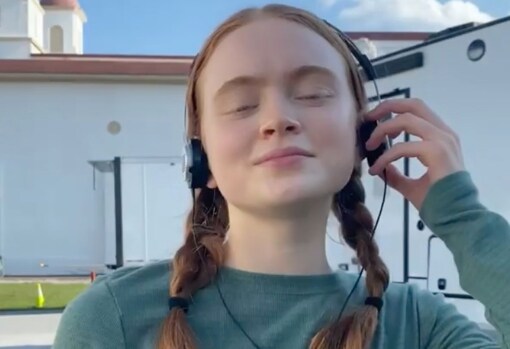 The redhead of the gang points to the braids ... and the walkman.