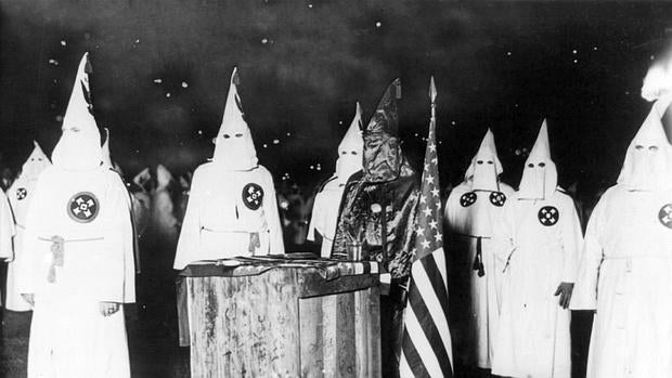 Miembros del Klan, junto a la bandera norteamericana