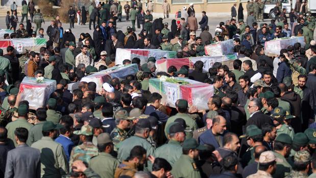 Iraníes cargando los ataúdes de las víctimas de un atentado suicida con bomba en un autobús de la Guardia Revolucionaria en el sureste de Irán
