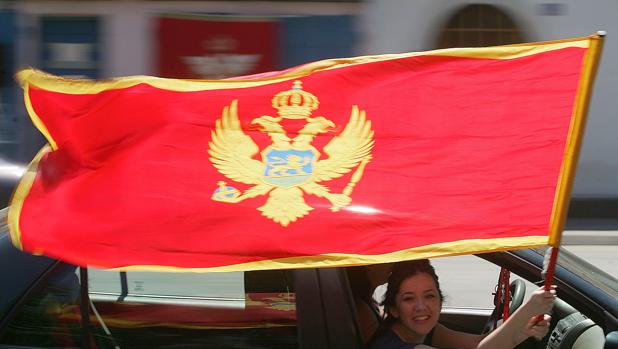 Una mujer sostiene la bandera de Montenegro tras la victoria del bloque independista en 2006