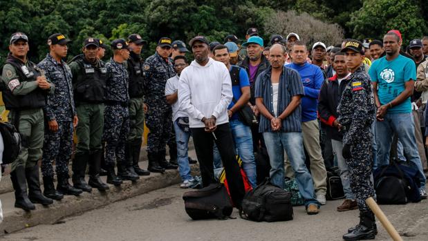 Efectivos de la Policía colombiana custodian a los ciudadanos liberados en la frontera entre ambos países