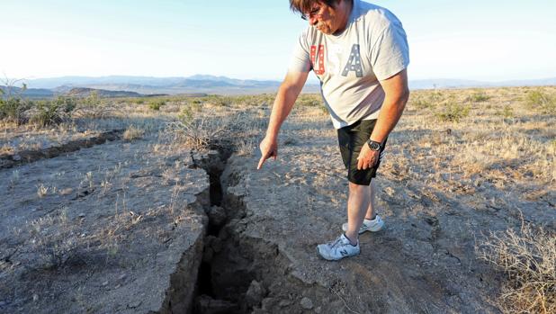 Un hombre señala la grieta dejada en el suelo del desierto el terremoto del jueves en el sur de California