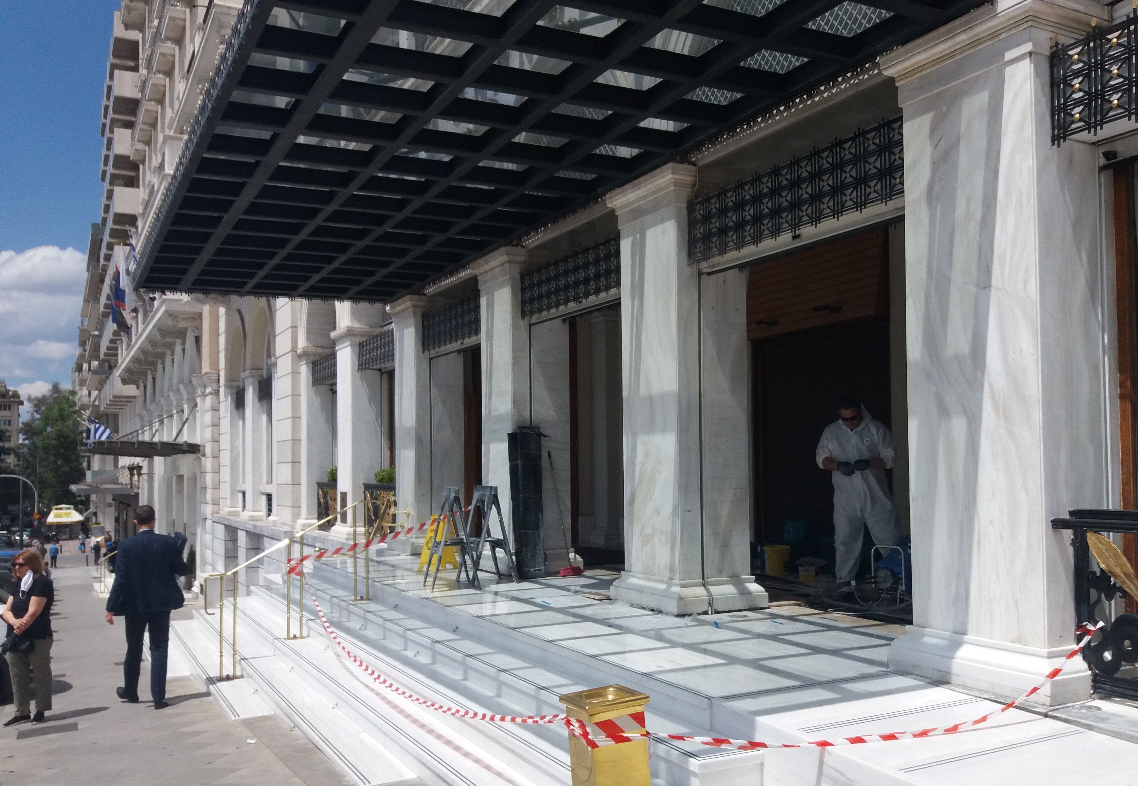 Operarios puliendo el mármol de la entrada del hotel grande Bretagne en la Plaza de la Constitución de Atenas